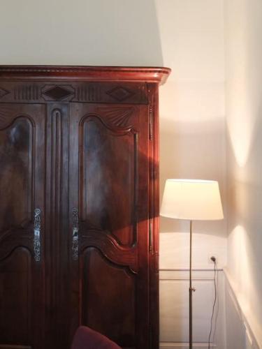 un grand meuble en bois avec une lampe à côté de celui-ci dans l'établissement CHARMING FLAT IN HISTORICAL CENTRE, à Dijon