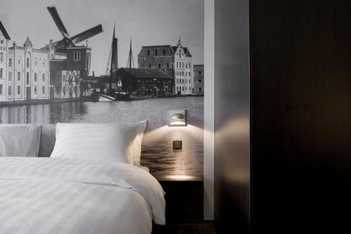 a bedroom with a bed and a view of a river at Inntel Hotels Amsterdam Zaandam in Zaandam