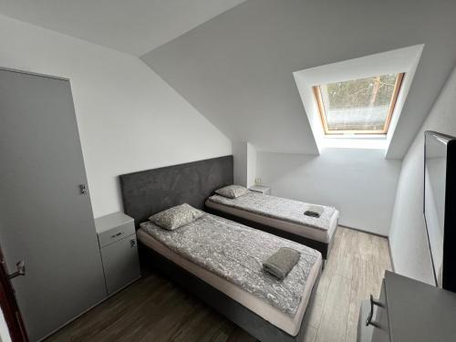 2 camas en una habitación pequeña con ventana en Rybaczówka Golub-Dobrzyń en Golub-Dobrzyń