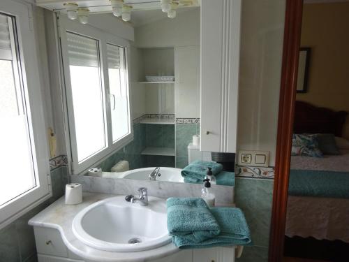 W łazience znajduje się umywalka, wanna i lustro. w obiekcie Piso Avenida Castelao XXL w mieście Isla de Arosa
