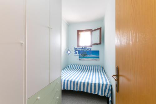 mały pokój dziecięcy z łóżkiem i drzwiami w obiekcie Residence Al Porticciolo w Cavallino-Treporti