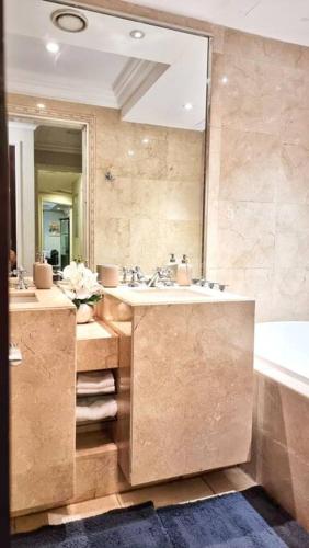 a bathroom with a sink and a tub and a mirror at ULTIMATE DXB DOWNTOWN PENTHOUSE in Dubai