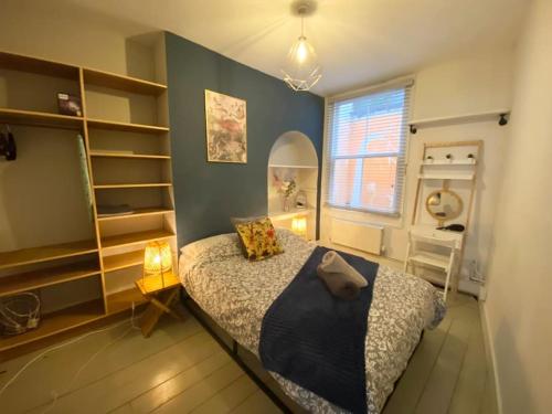 a bedroom with a bed with a blue wall at Old Fisherman Nest in Old Town in Hastings