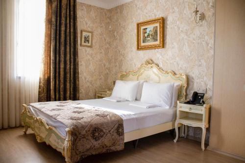 a bedroom with a bed and a table with a phone at La Casa Old City Hotel in Baku
