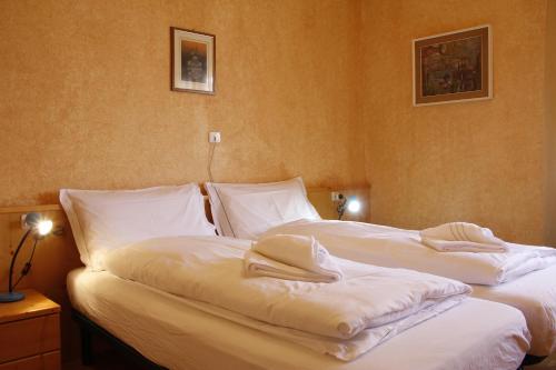 Dos camas en una habitación de hotel con toallas. en Villa Ginestra - 1, en Moena