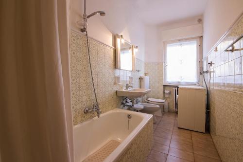 y baño con bañera, aseo y lavamanos. en Villa Ginestra - 1, en Moena