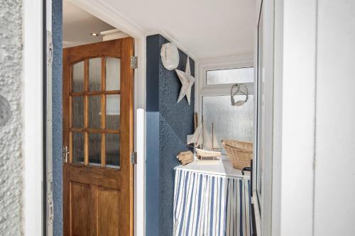 a hallway with a door and a table with a mirror at Portsea - Sea Views Close to Beach in Saundersfoot