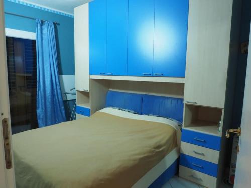 a small bedroom with blue cabinets and a bed at Trinità d'Agultu-Isola Rossa, località La Frisaia, entire apartment, sleeps 6 in Trinità d'Agultu e Vignola
