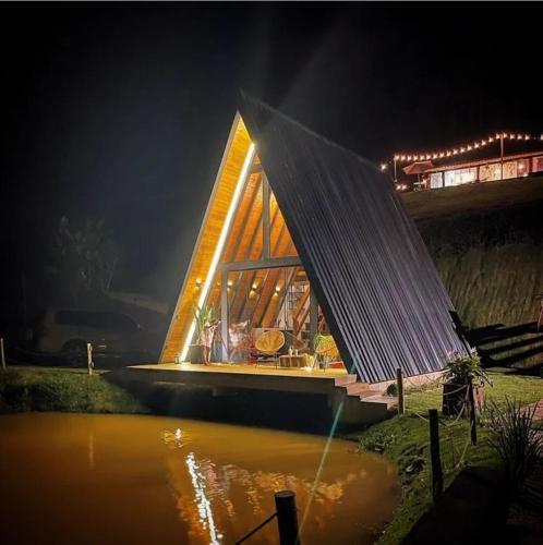 un barco con techo sobre el agua por la noche en Cabana A frame Paraíso nas Montanhas, en Marechal Floriano