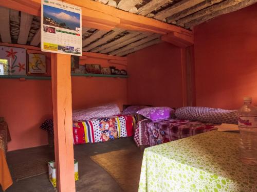 een kamer met drie bedden en een bord erin bij Hemjakot Community Homestay in Pokhara