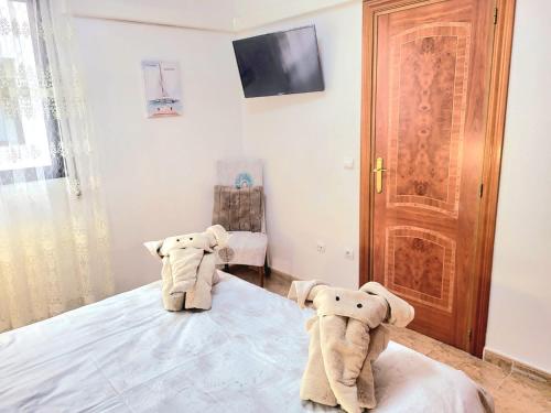 two stuffed elephants sitting on a bed in a bedroom at Sea Breeze Apartament in Benicarló