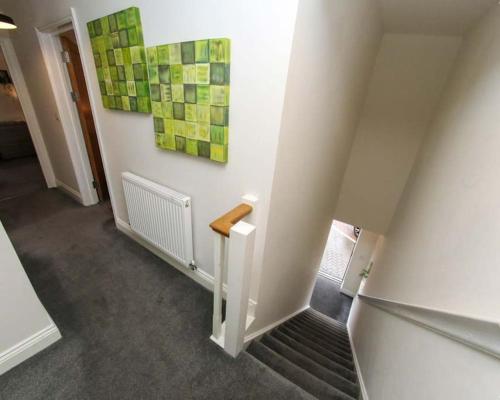 a hallway with a staircase with a stair railing and a painting at Luxe Living Guest House-Sleeps 6-Private Parking-Free WIFI-Beach-City in Swansea