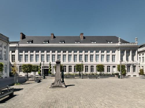 a large white building with a statue in front of it at Juliana Hotel Brussels in Brussels
