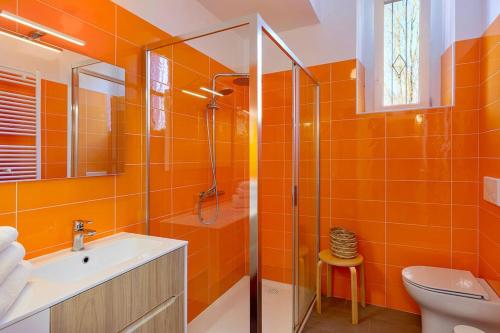 een oranje badkamer met een douche en een wastafel bij Spacious new 2 bdr walk-out apartment in Fara Novarese