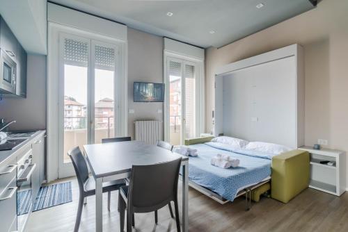una camera con letto, tavolo e sedie di Pavia Tower - by Host4U a Pavia