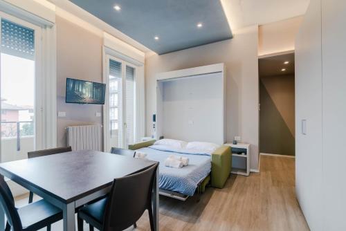 a room with a bed and a table and chairs at Pavia Tower - by Host4U in Pavia