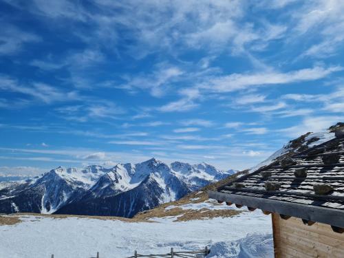 a view of snow covered mountains from a roof at Natur Pur Hotel Unterpichl in Ultimo