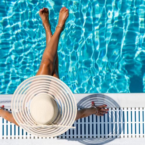a woman in a hat and a swimming pool at Masseria Cricelli in Lizzanello