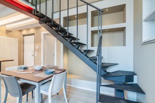 a staircase in a dining room with a table and chairs at Pavia Tower - by Host4U in Pavia