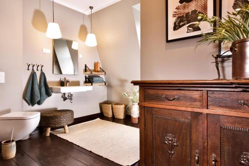 a bathroom with a sink and a toilet and a wooden cabinet at Villa B - Neuer Geist in alten Mauern: luxuriös Wohnen in der Residenzstadt Gotha in Gotha