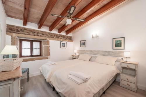 sypialnia z dużym łóżkiem i wentylatorem sufitowym w obiekcie Villa Agnes w mieście Pollença