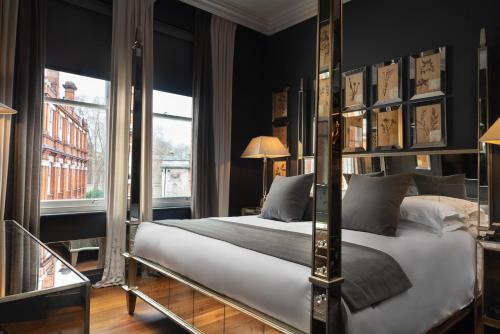 a bedroom with a four poster bed and a window at The Franklin London - Starhotels Collezione in London