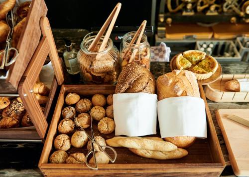 a wooden box filled with lots of different types of bread at Juliana Hotel & Spa - Brussels Centre in Brussels