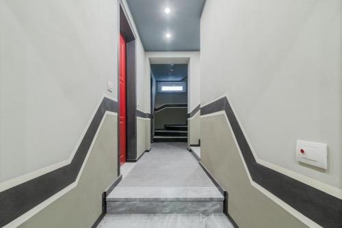 a hallway with stairs and a red door at Pavia Tower - by Host4U in Pavia