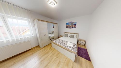 a bedroom with a bed and a window at Harmony Apartment VRT in Şelimbăr