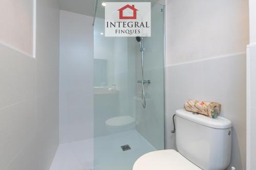 een witte badkamer met een toilet en een douche bij Blau Marí Apartament Palamós in Palamós