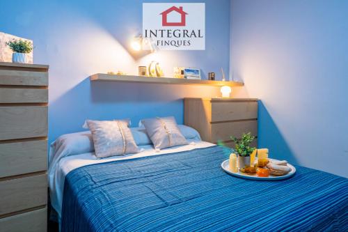 een blauwe slaapkamer met een bed met een bord eten erop bij Blau Marí Apartament Palamós in Palamós