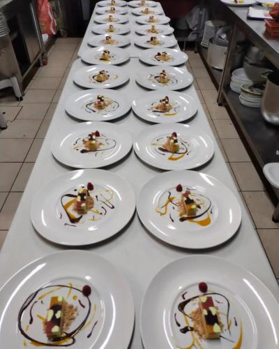 a long table with white plates with food on them at Hotel Martin in Volpiano