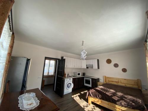 a room with a bed and a kitchen with a refrigerator at Карпатська тиша in Sheshory