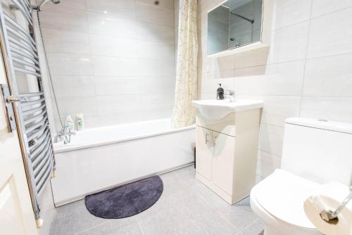 a bathroom with a tub and a sink and a toilet at Flat 02 Studio Luton 53 free Parking in Luton