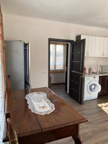 eine Küche mit einem Holztisch und einem Kühlschrank in der Unterkunft Біля річки in Scheschory
