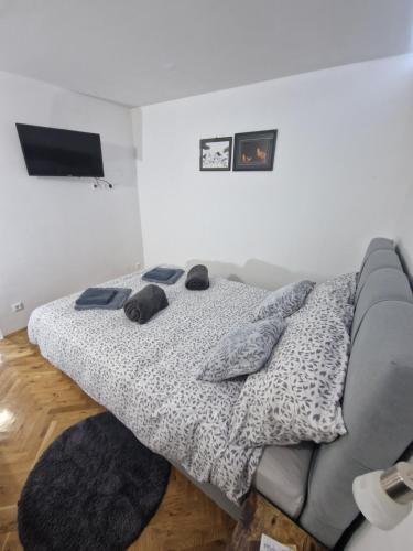 a bedroom with a bed and a television on the wall at B-TIM Apartment in Velika Gorica