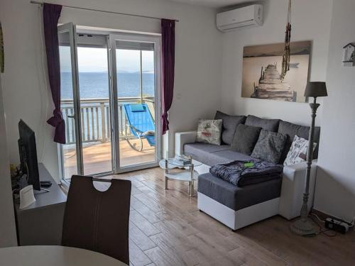 a living room with a couch and a view of the ocean at Appartement Blue Lagune 4 Sterne in Prizna