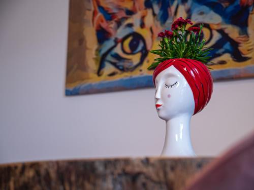 a vase with a red head with a flower on it at Mansarda Le Torri in Mantova