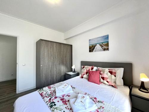 a bedroom with a large bed with pink pillows at Portimão Central by Homing in Portimão