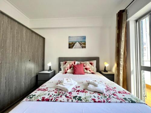 a bedroom with a large bed with pink pillows at Portimão Central by Homing in Portimão