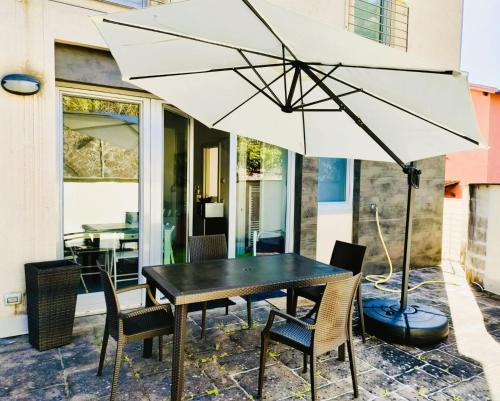 - une table et des chaises avec un parasol sur la terrasse dans l'établissement Appartamento Magnolia Residenza Prealba, à Levanto