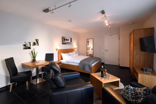 um quarto de hotel com uma cama e uma sala de estar em Weingut Heinen em Longuich