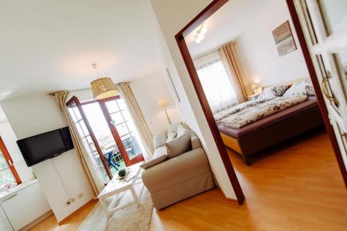 een slaapkamer met een bed, een bank en een televisie bij Das Harznest, WLAN in Bad Sachsa