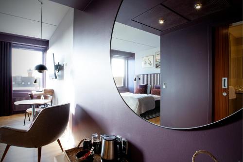 a room with a mirror and a bedroom with a bed at Hotel Britannia in Esbjerg