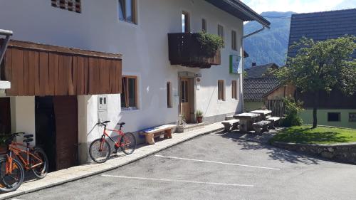 two bikes parked in a parking lot next to a building at Apartments & Hostel Bohinj in Bohinj
