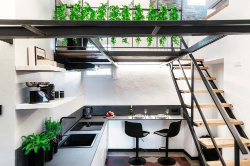 a loft kitchen with a ladder and stools at Casa Dei Viaggiatori - The House Of Travelers in Como