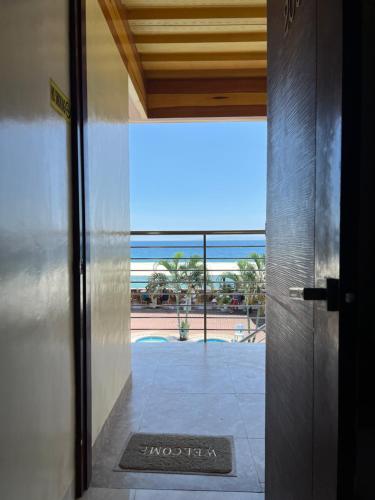 an open door with a view of the ocean from a building at GingGing Hotel And Resort in Oslob