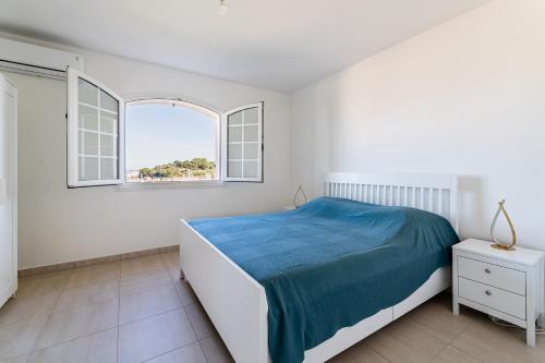 une chambre blanche avec un lit et deux fenêtres dans l'établissement Superbe appartement 2 chambres en haut de Villa, à Saint-Mandrier-sur-Mer