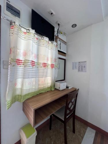 a room with a desk and a curtain on a wall at GingGing Hotel And Resort in Oslob