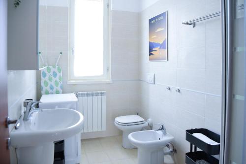ein weißes Bad mit einem Waschbecken und einem WC in der Unterkunft Blue Bellagio by Wonderful Italy in Bellagio